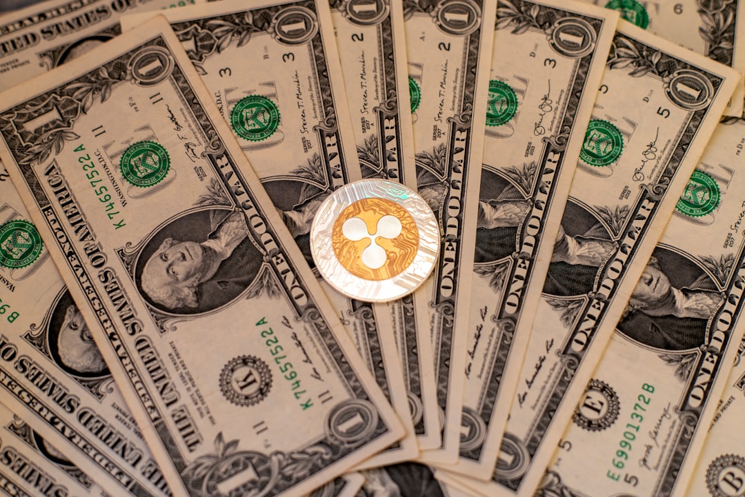 달러 지폐 위에 놓인 리플(XRP) 코인 — 결제용 코인 XRP를 상징하는 이미지